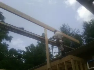 Carpenter setting a ridge beam over a new addition frame — Ice Dam Removal by Roofing Brothers in Wethersfield