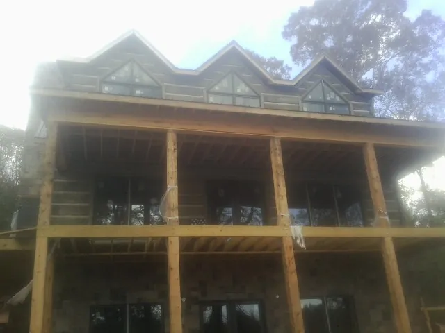 Dormers and porch framing on a large log home under construction — Roof Coating work by our crew in Wethersfield
