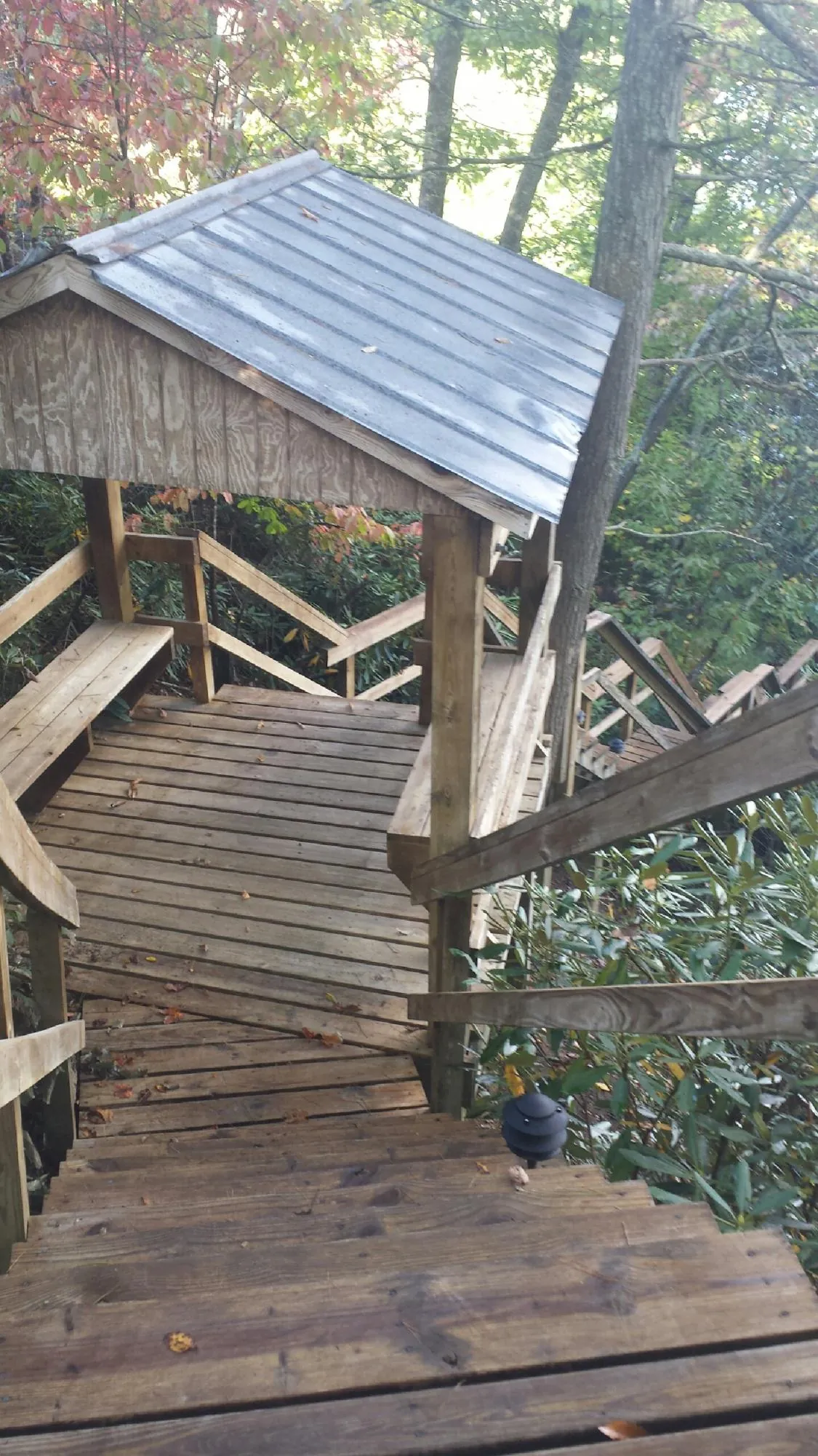 Metal roofed shelter over wooden steps on a wooded walkway — Skylight Repair & Installation work by our crew in Wethersfield
